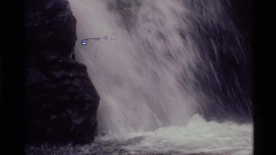 1972 8mm Holland Lake waterfall detail, with fast water blurred against dark rock and foam below.