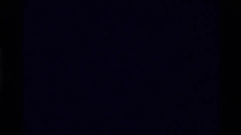 Dark 8mm transition frame from the 1972 Holland Lake footage, with most landscape detail obscured by underexposure or splice timing.