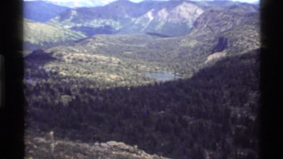 Final 1972 Holland Lake, Montana frame showing the alpine lake tucked among forest and mountain slopes.