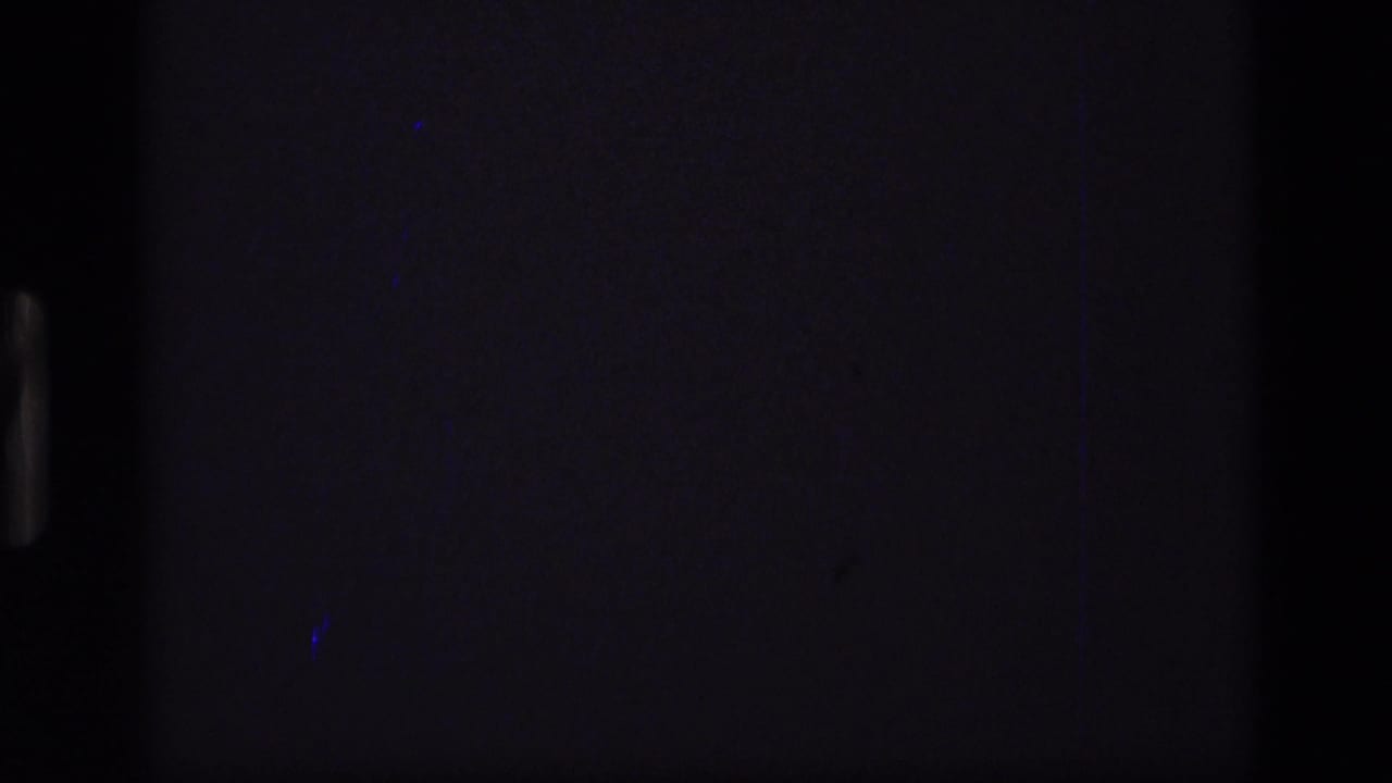 Dark opening 8mm frame from the 1972 Idaho clip, showing little detail beyond film edges and faint scan artifacts.