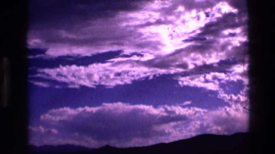 1972 Idaho 8mm view of purple-blue clouds over a dark horizon, likely filmed at dusk or dawn.