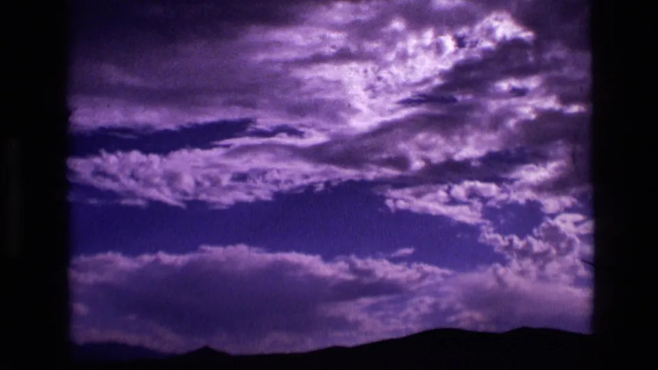Final 1972 Idaho 8mm frame showing dramatic purple cloud texture above a low dark landscape silhouette.