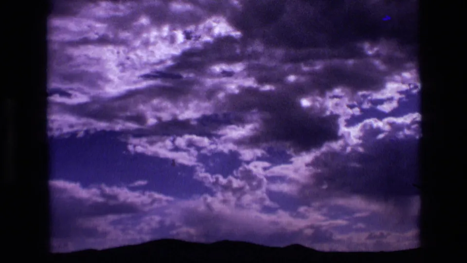 1972 Idaho 8mm view of heavy purple clouds over a distant mountain ridge.