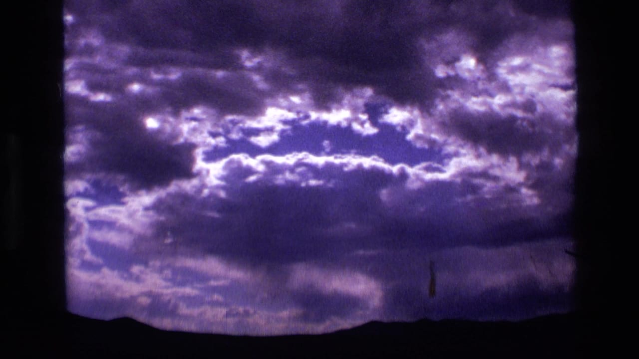 Cloud bank with bright sky breaks over a low mountain silhouette.
