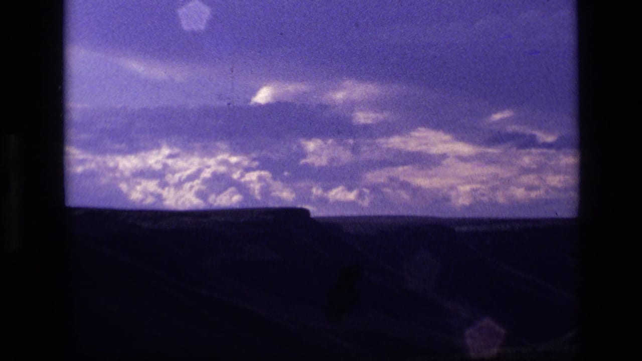 1972 Idaho 8mm frame showing purple twilight clouds over a dark, low landscape silhouette.