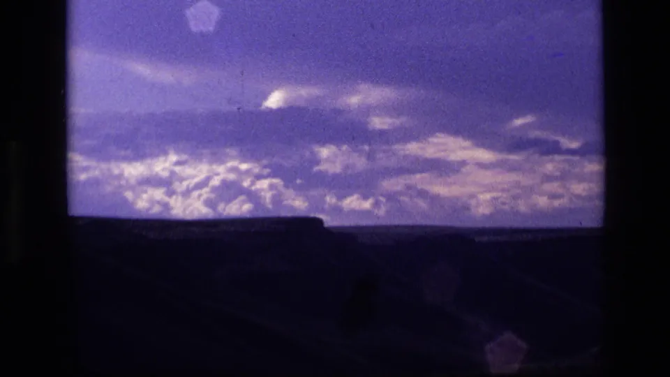 1972 Idaho 8mm frame showing purple twilight clouds over a dark, low landscape silhouette.