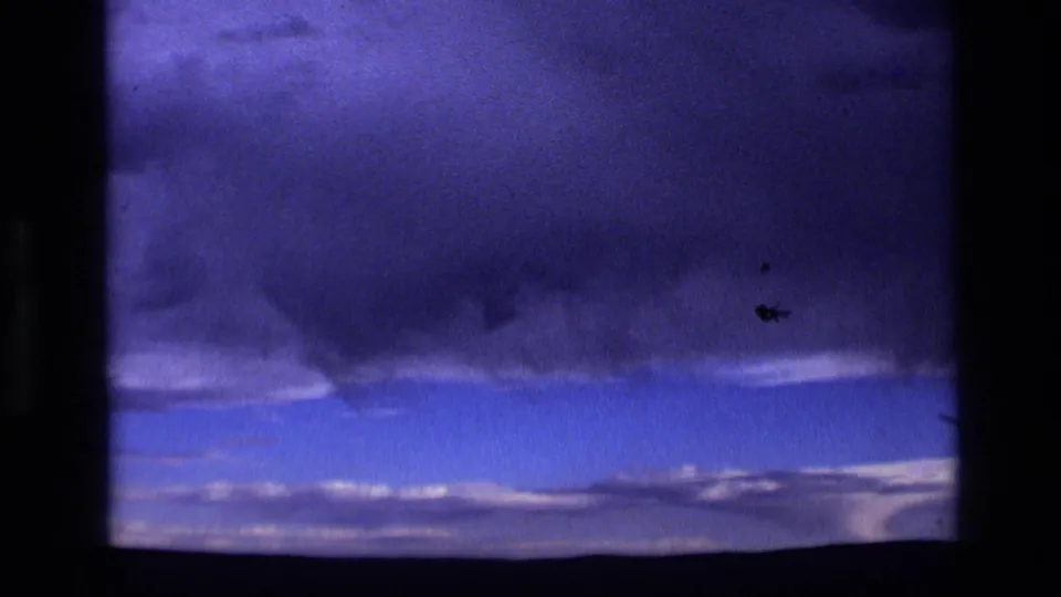 1972 Idaho 8mm frame showing a brooding storm sky over a sparse, dark horizon line.