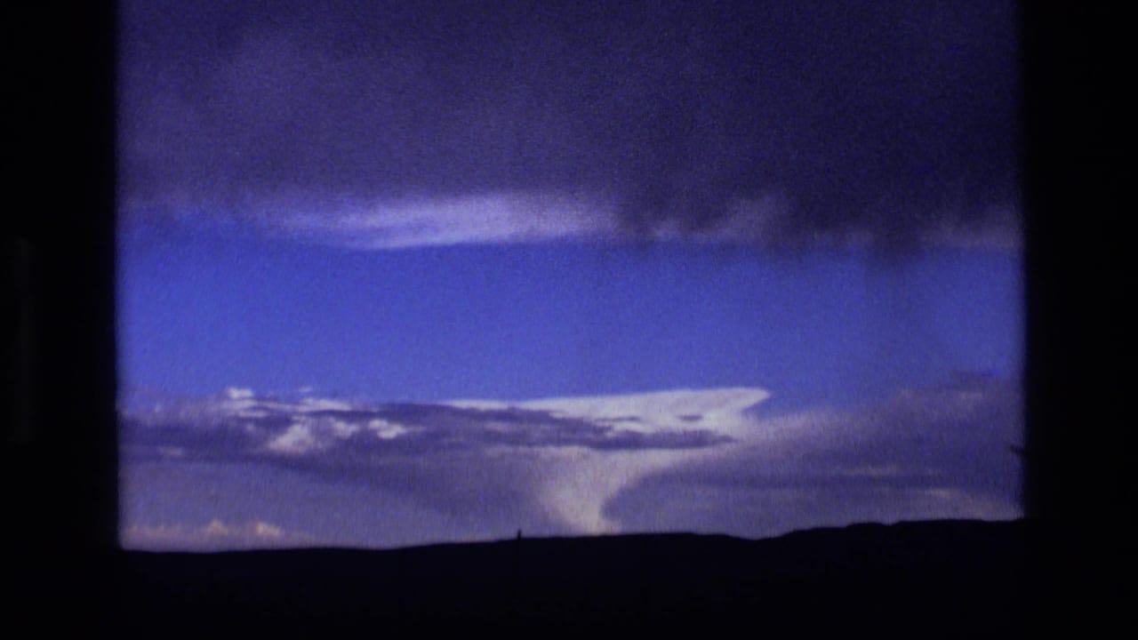 Archival 8mm view of a storm cell over Idaho plains, with bright cloud tops and a dark upper cloud band.