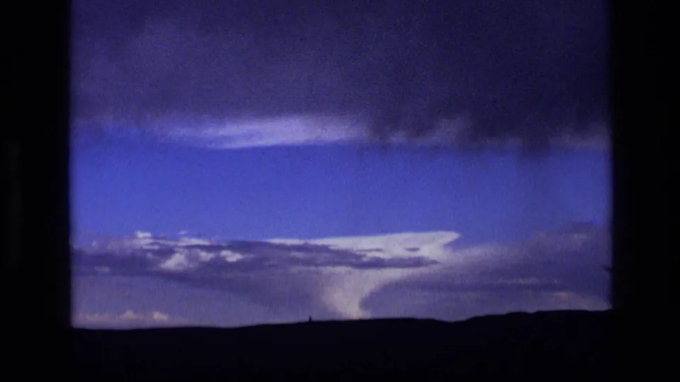 Archival 8mm view of a storm cell over Idaho plains, with bright cloud tops and a dark upper cloud band.