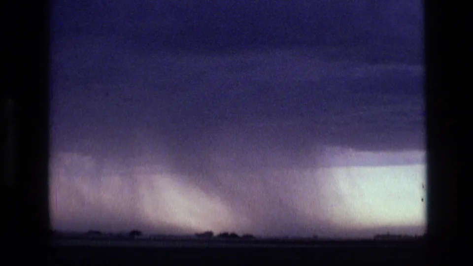 Final 8mm frame shows dark storm clouds and a bright rain shaft or illuminated storm area near the Idaho horizon.