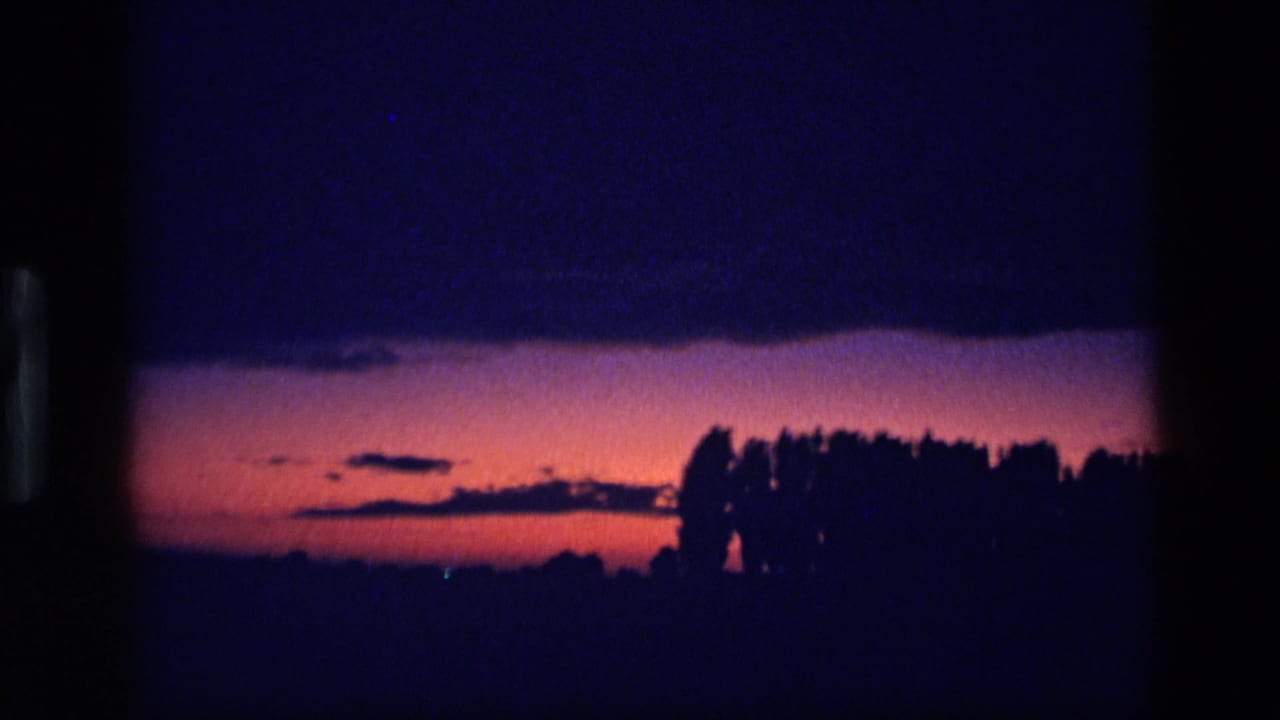 1972 Idaho 8mm frame showing a purple and pink dusk sky above a silhouetted treeline.