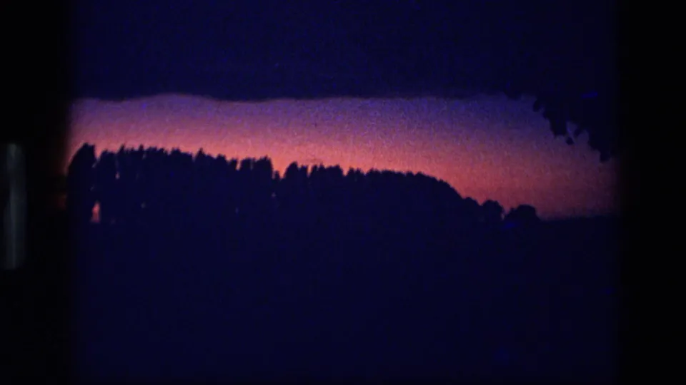 1972 Idaho 8mm frame with the treeline nearly black against a low purple-pink dusk glow.