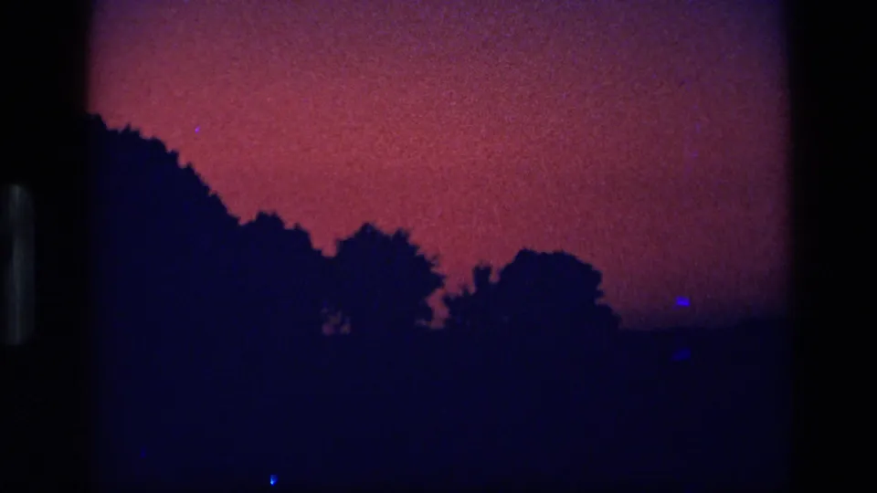 1972 Idaho 8mm frame showing a magenta-purple dusk sky above dark tree silhouettes.