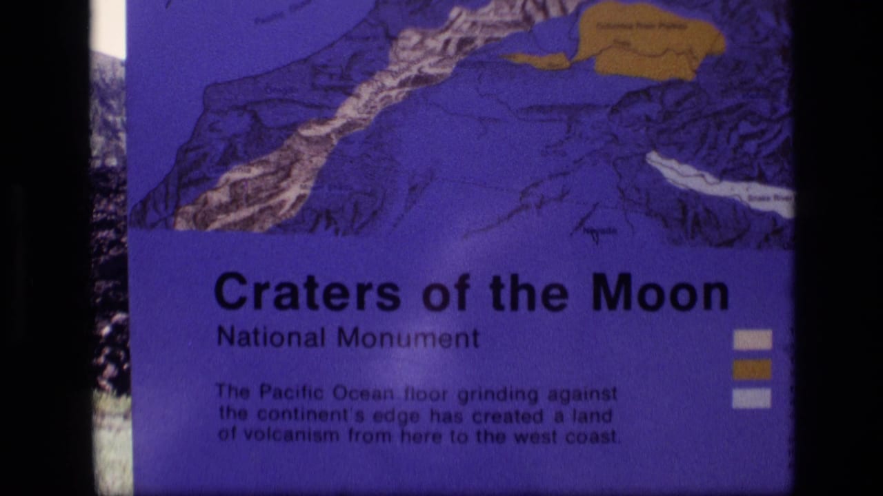 1972 Idaho 8mm frame showing the Craters of the Moon National Monument sign with a purple-toned geology map and explanatory text.