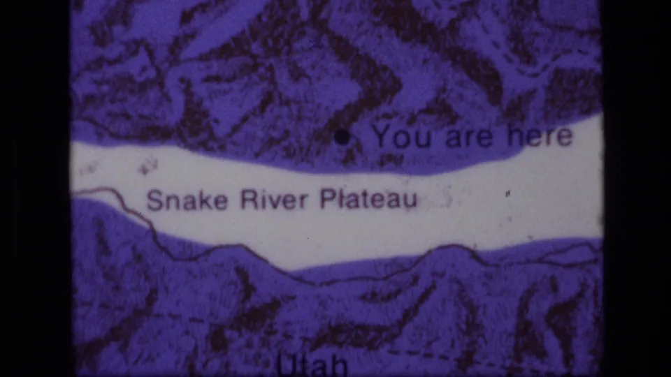 1972 8mm frame showing a purple-tinted Snake River Plateau map with a You are here marker and Idaho-Utah area labels.