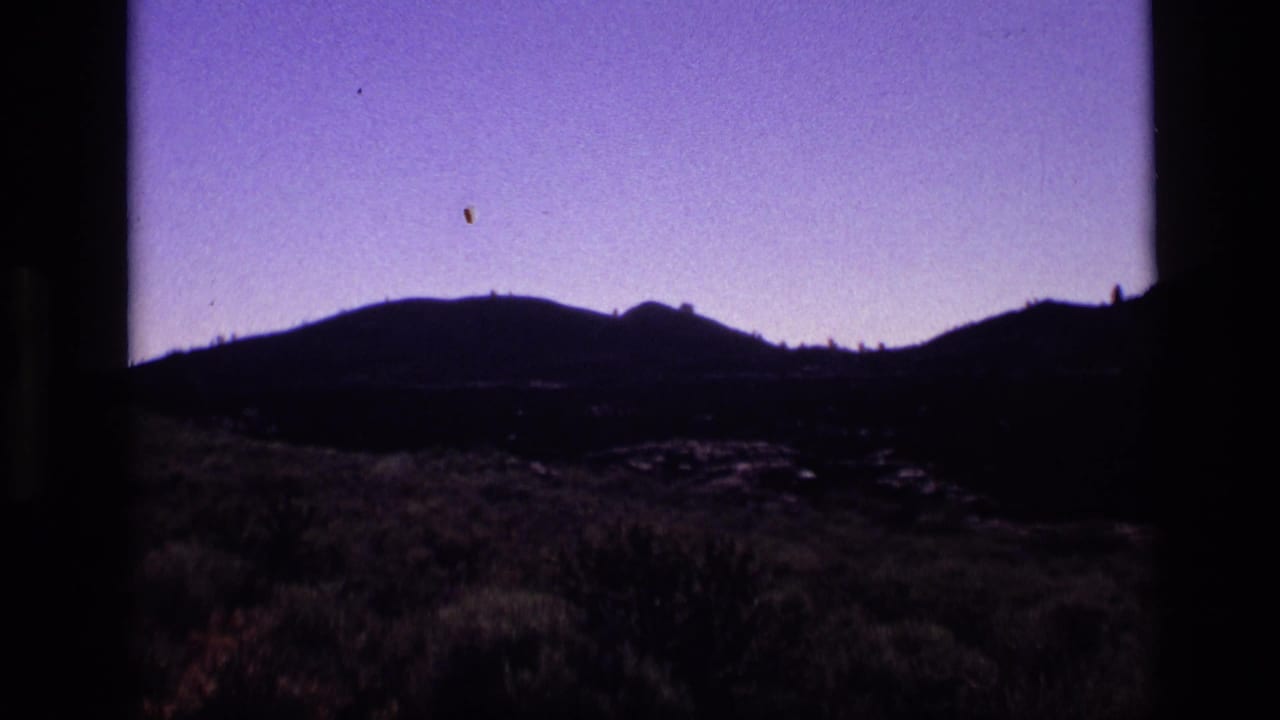 1972 Idaho 8mm frame showing a violet evening sky above silhouetted mountains and low desert vegetation.