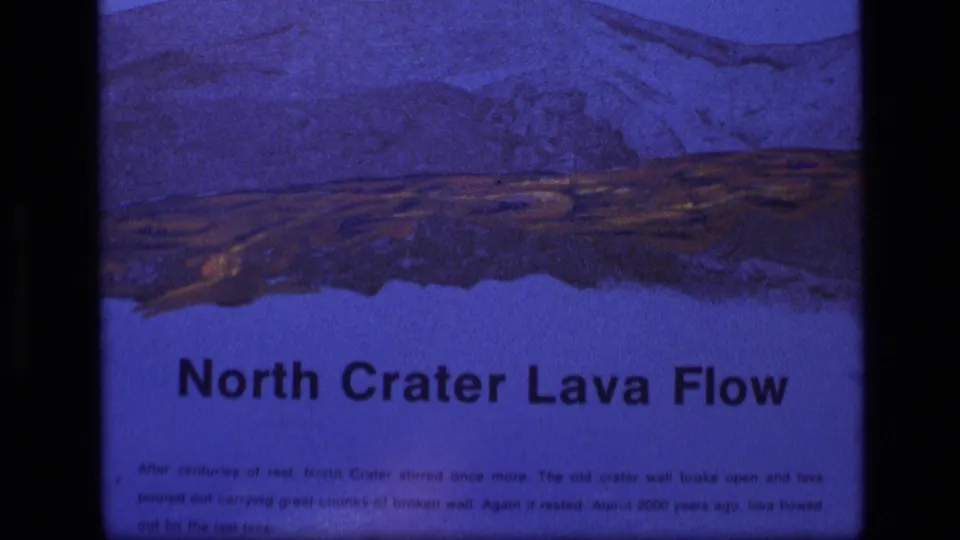 1972 Idaho 8mm frame showing the North Crater Lava Flow title below a blue-toned volcanic landscape illustration.