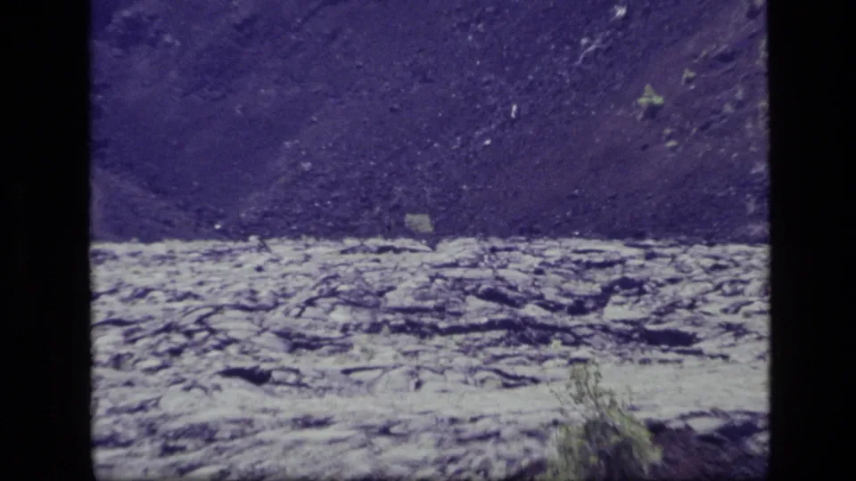 1972 Idaho 8mm view across the North Crater Lava Flow, showing rough rock, small brush, and a shadowed volcanic slope.