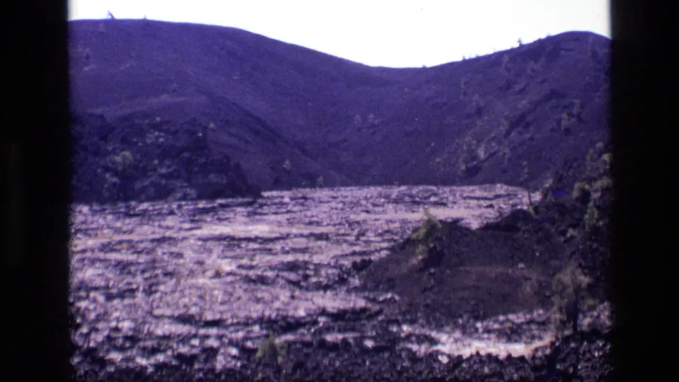 Final 1972 Idaho home-movie frame showing the lake, surrounding hills, sparse shrubs, and visible 8mm film edges.