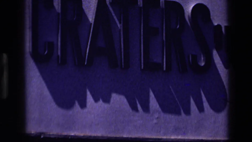 1972 Idaho 8mm frame showing a partial purple-lit sign with CRATERS lettering, likely a location or commercial marker.