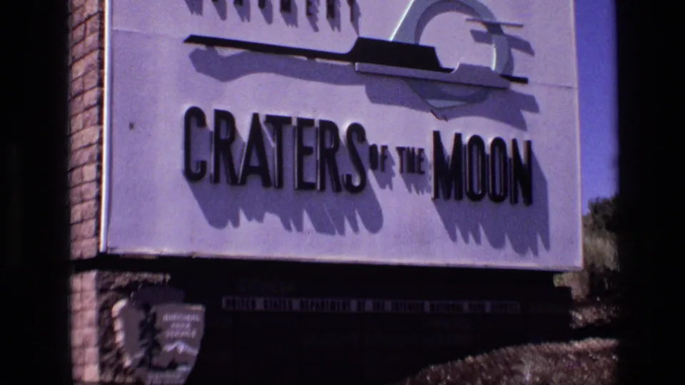 1972 8mm view of the Craters of the Moon National Monument sign in Idaho, partly cropped by dark frame edges.