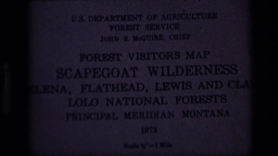 Dark close-up of a 1973 U.S. Forest Service visitors map for Scapegoat Wilderness in Montana national forests.