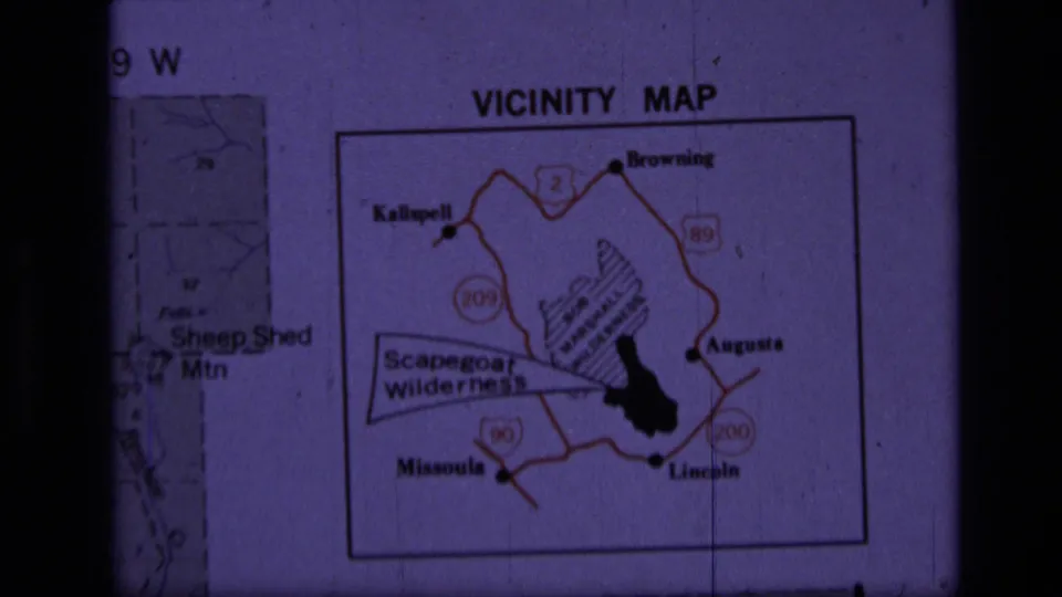 Projected 1970s Montana vicinity map slide showing Scapegoat Wilderness, nearby town labels, and red road markings.