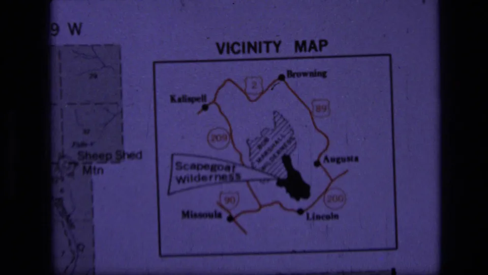 Soft 8mm frame of a projected Scapegoat Wilderness vicinity map, with route numbers and Montana town labels visible.