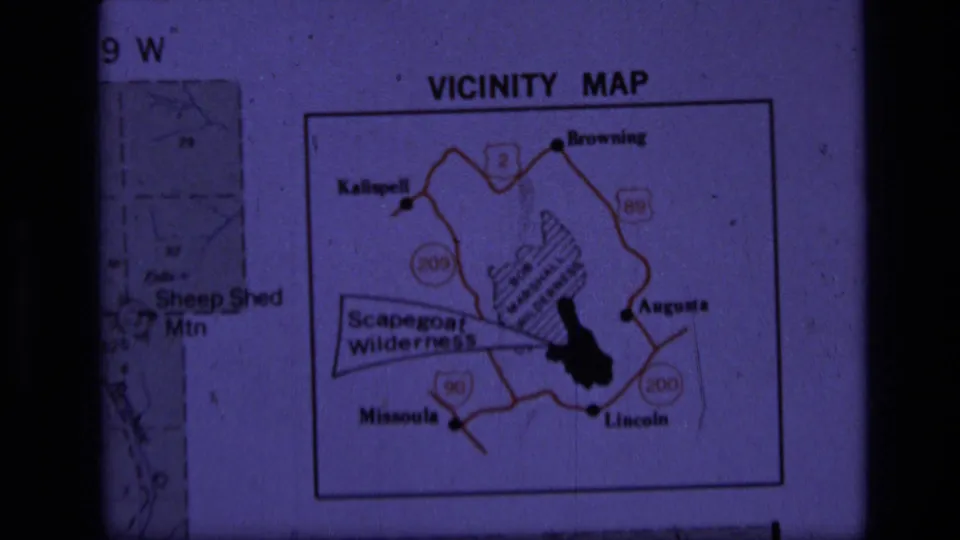 1973 8mm frame showing the projected Scapegoat Wilderness vicinity map, including highlighted terrain, roads, and town labels.