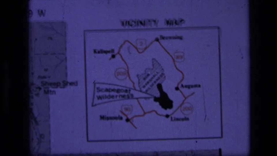 1973 8mm frame showing a purple-tinted projected vicinity map for Scapegoat Wilderness in Montana.
