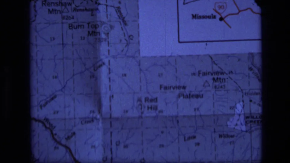 Projected 8mm frame of a Montana map detail below the Scapegoat Wilderness vicinity inset, with mountain labels visible.