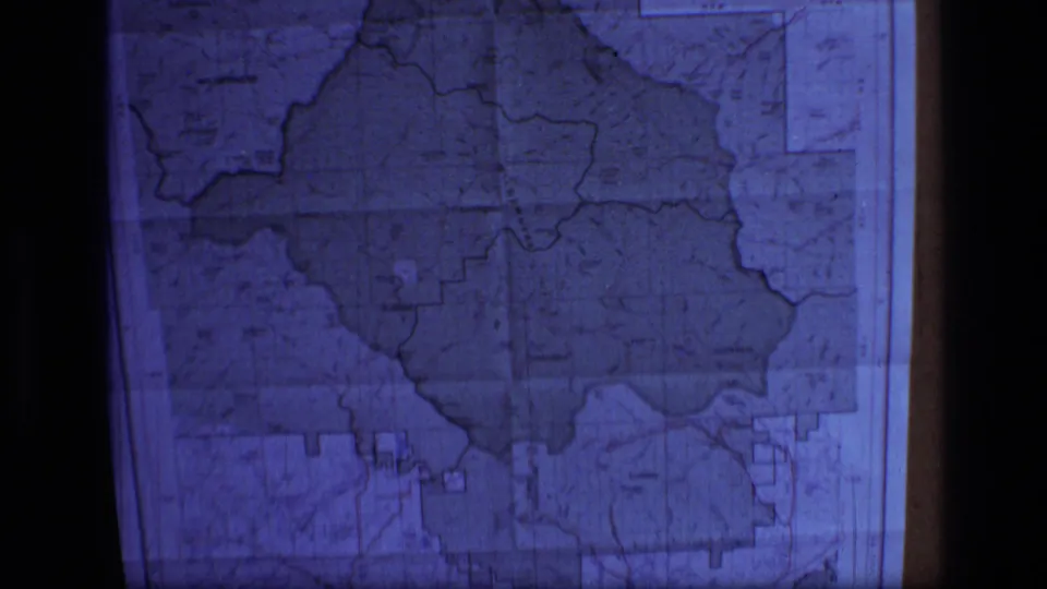 Final frame of the 1973 8mm clip holds on a blue-lit Scapegoat Wilderness map with visible boundary shapes and projection edges.
