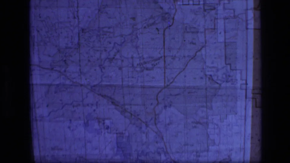 Close Super 8 view of a Montana wilderness-area map section with grid lines, route markings, and visible projection edges.