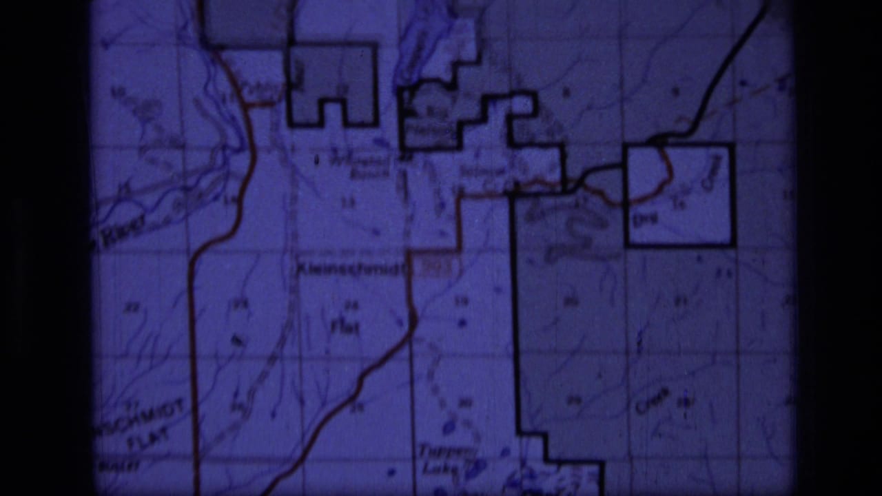 1973 8mm frame showing a purple-tinted topographic map of the Scapegoat Wilderness area with grid and contour details.