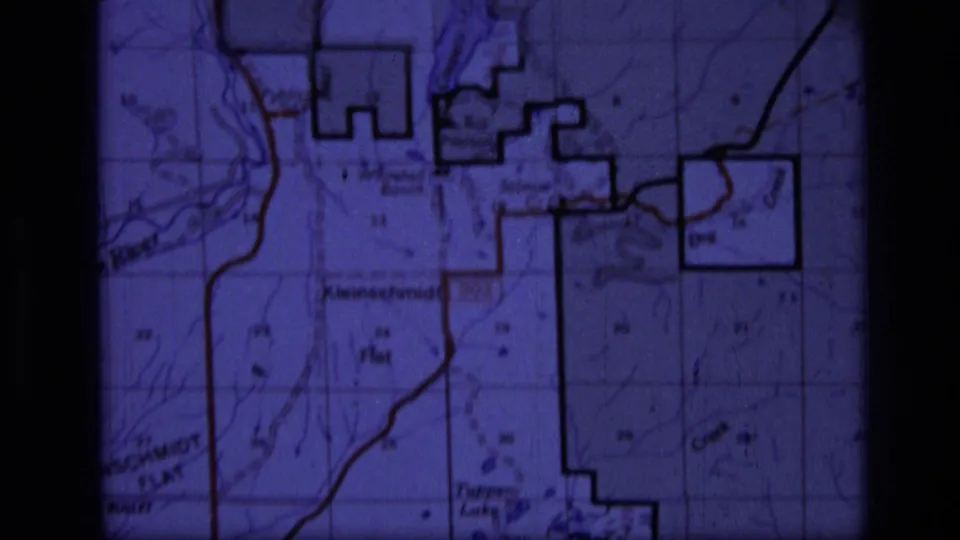 1973 8mm frame showing a purple-tinted topographic map of the Scapegoat Wilderness area with grid and contour details.