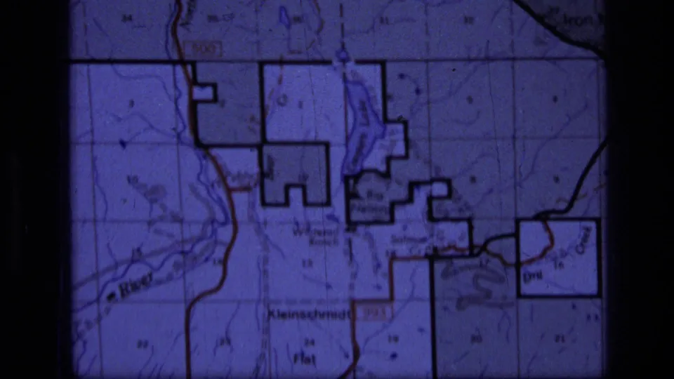 Purple-tinted 8mm frame of the Scapegoat Wilderness map area, with Kleinschmidt Flat and surrounding grid details visible.
