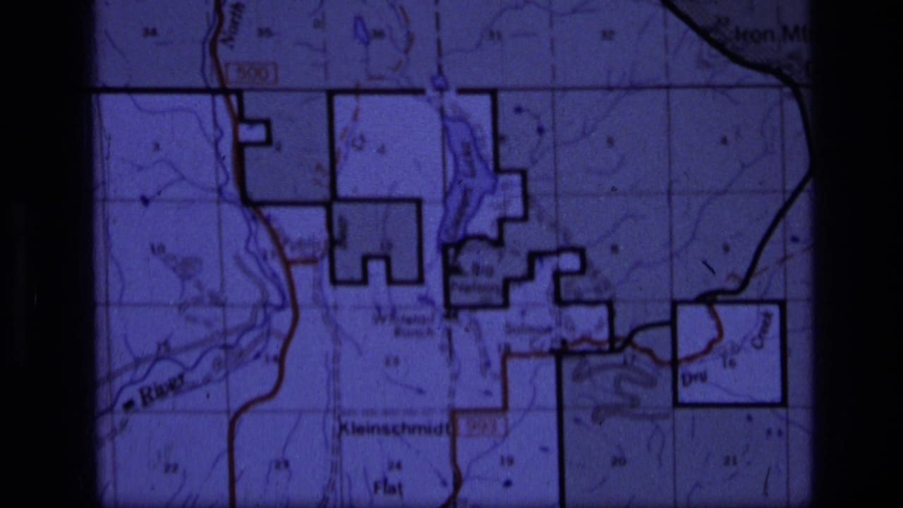 Purple-tinted close view of a topographic map with grid lines and labeled flats.