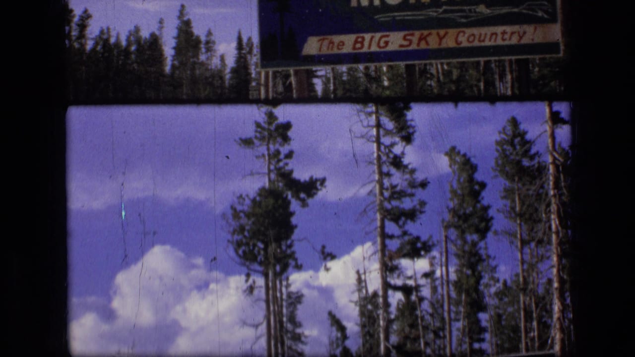 1973 Montana 8mm frame showing a Big Sky Country roadside sign over pine trees, blue sky, and white clouds.