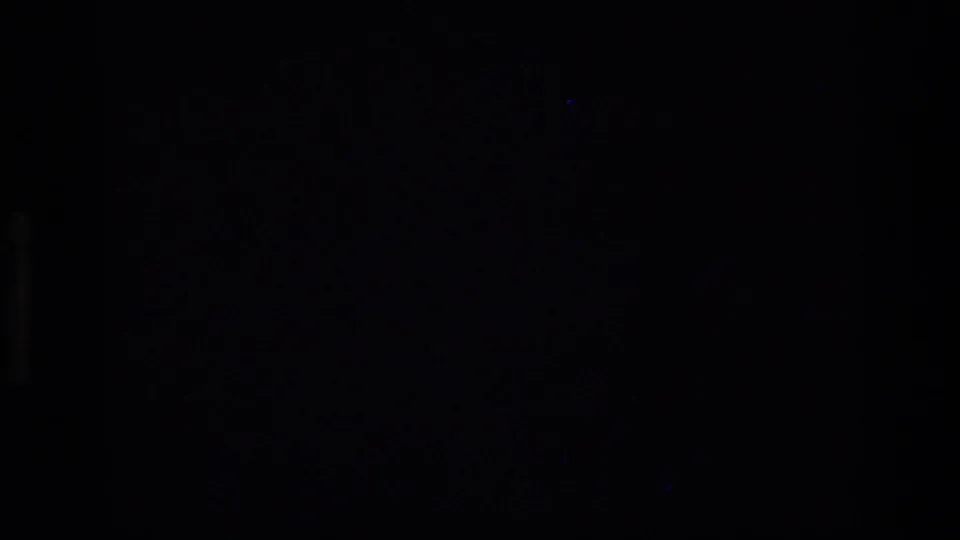 Underexposed or obstructed transition frame from the 1973 Montana 8mm clip, with no clear subject visible.