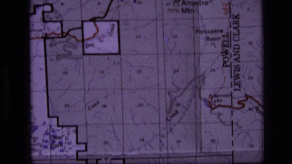 1973 8mm frame showing the Scapegoat Wilderness map near Porcupine Basin, with grid sections, terrain contours, and boundary labeling.