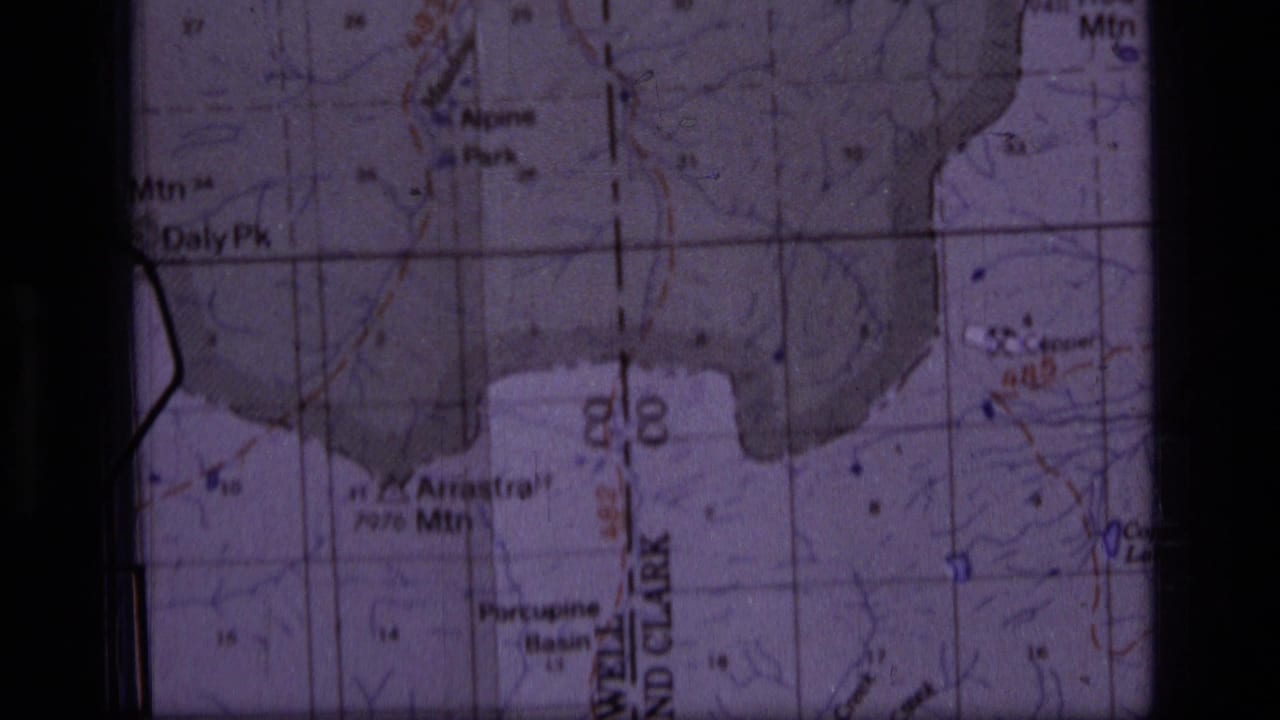 Close view of a topographic map section with Daly Peak, Alpine Park, grid lines, and dark film borders.