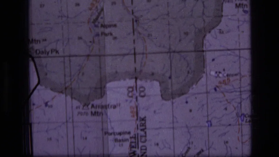 1973 8mm frame showing a Montana topographic map near Daly Peak and Alpine Park, with contour markings and soft purple film color.
