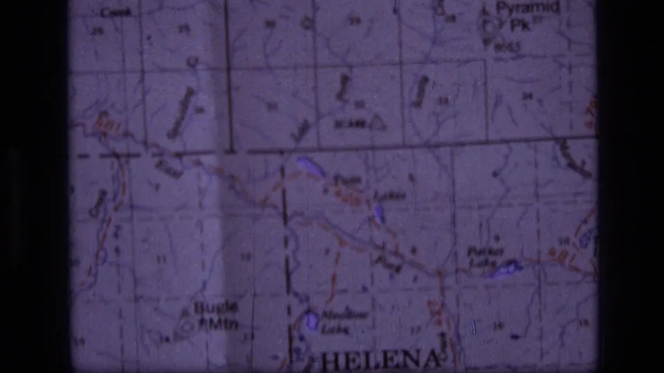 1973 8mm frame showing a close-up of a Helena, Montana area topographic map with Bugle Mtn and Pyramid Peak labels visible.