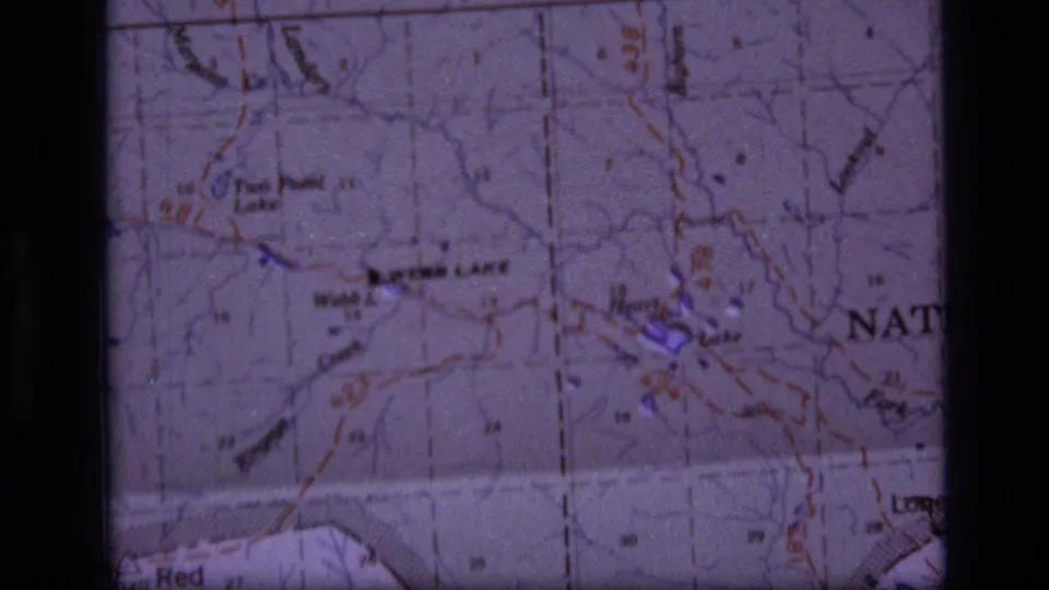 Close 1973 home-movie frame of a Montana wilderness topographic map, centered on Webb Lake, Heart Lake, and surrounding route markings.