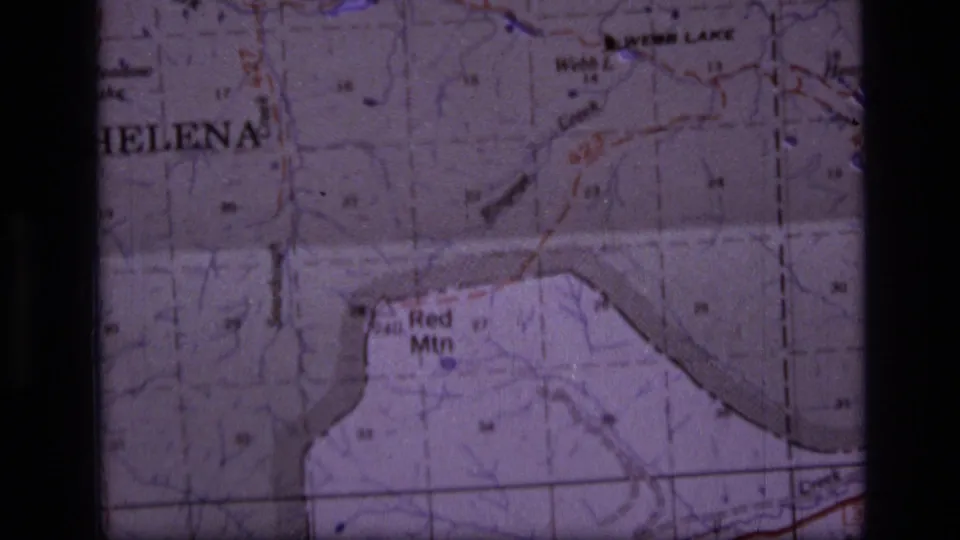 1973 8mm frame of a Montana topographic map where Helena, Webb Lake, and Red Mtn labels appear amid grid and contour details.