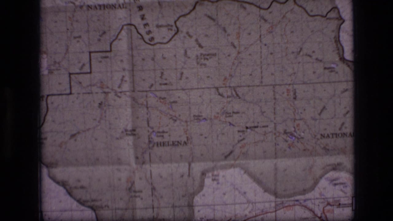 1973 8mm frame of a Montana map showing forest boundary markings, Helena-area labels, and a central dark film divider.