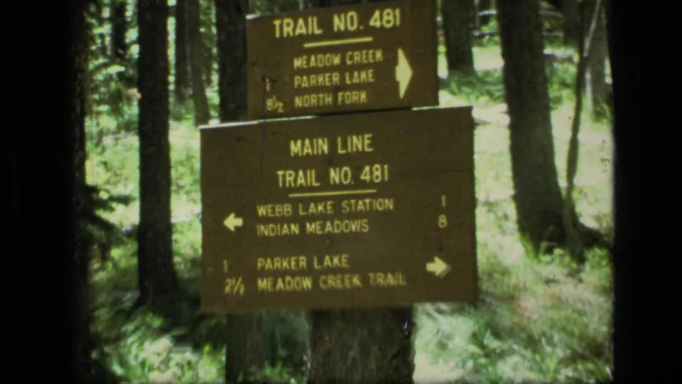 Closer 1973 8mm view of the Main Line Trail No. 481 marker, including directions for Webb Lake Station and Indian Meadows.