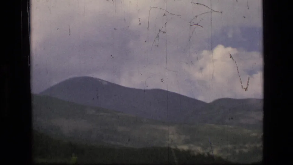 1973 Scapegoat Wilderness footage opens on dark mountain ridges and clouded sky with visible 8mm film wear.