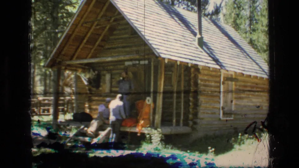 A final wide frame shows the Montana log cabin exterior, men near the porch, outdoor gear, trees, and strong 8mm sunlight.