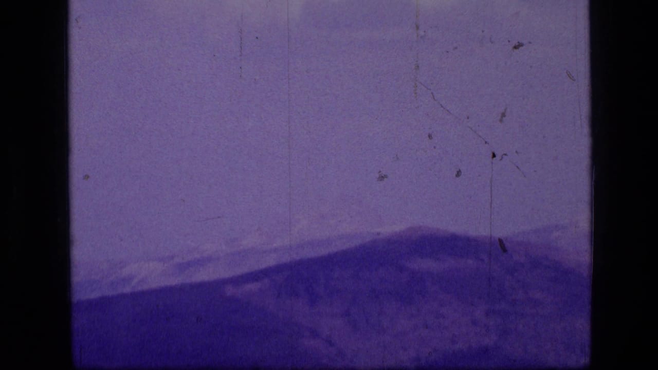 Scapegoat Wilderness ridgelines are seen in a purple-tinted 1973 8mm home-movie frame.